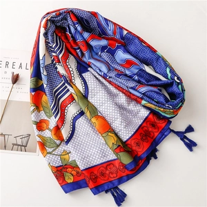 Detail of bohemian scarf with citrus totem prints and navy blue tassels on a silk fabric