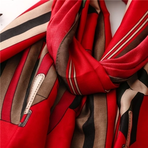 Détail d'un foulard en soie rouge avec imprimé chaîne et texture satinée