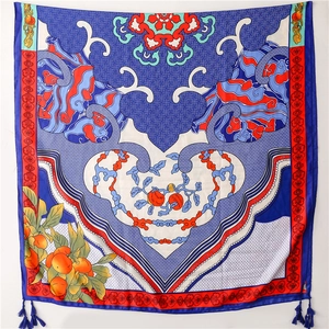 Detail of silk scarf with oriental patterns, orange motifs, and blue tassels