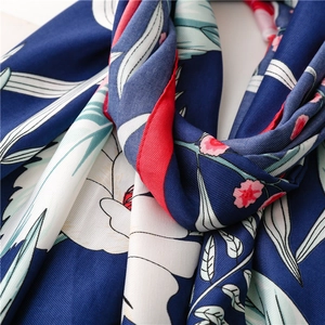 Close-up of floral silk scarf showing premium twill fabric texture and vivid floral patterns