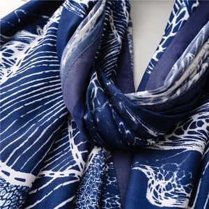Detailed macro shot of the abstract coral print and smooth silk texture on the beach shawl