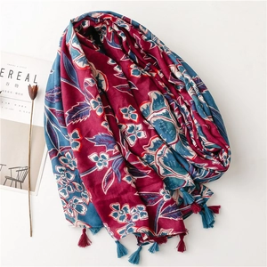 Detail of red and blue floral scarf with soft cotton linen texture and fringe tassels