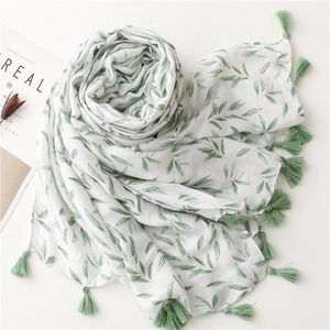 Close-up of white cotton linen scarf with soft willow leaf prints and tassel fringe