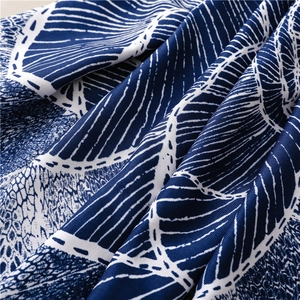 Close-up of navy blue and white ethnic print fabric showing soft texture and tassels