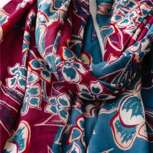 Close-up of soft floral cotton linen scarf with ethnic patterns in deep red and blue