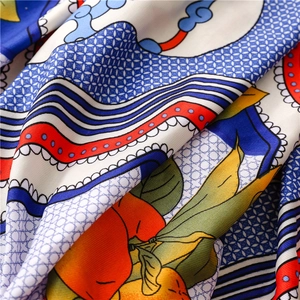 Macro detail of silk scarf showing ethnic totem print and premium twill fabric texture