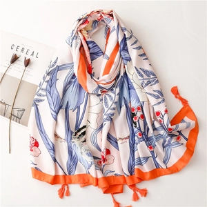 Floral print beach shawl with orange tassels and blue leaf patterns on white silk