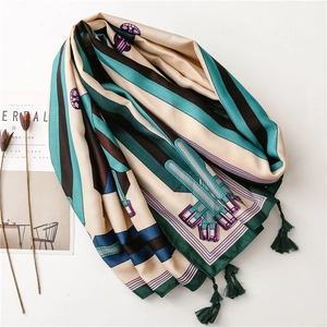 Détail d'un foulard en soie avec motif de boucles vintage et pompons verts