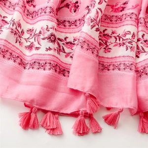 Detail of pink floral scarf with soft cotton-linen texture and tassel fringe edge