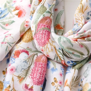 Gros plan détaillé de l'écharpe légère au toucher lin avec d'élégants motifs floraux