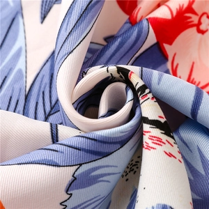 Detail of floral silk scarf showing soft twill fabric texture and fringe tassel