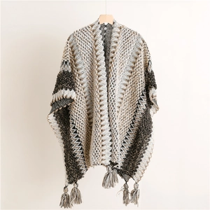 Detailed view of bohemian knit poncho with geometric patterns and fringe tassels