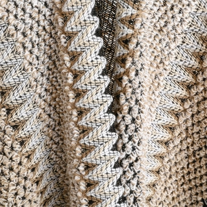 Macro detail of multi-color zigzag knit texture on travel shawl wrap fabric