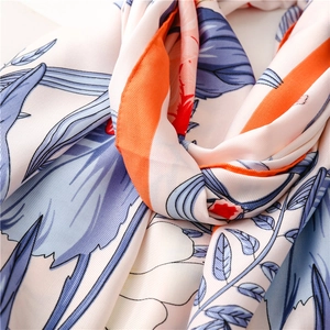 Close-up of floral silk scarf showing elegant blue patterns and soft satin texture
