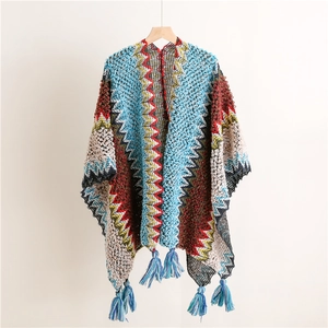 Detail of geometric wave knit pattern and fringe hem on ethnic style poncho shawl