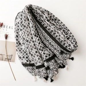 Detail view of cotton-linen shawl with clover patterns and tassel fringe decorations