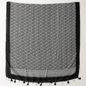 Detail of soft black and white scarf featuring star geometric patterns and fringed edges