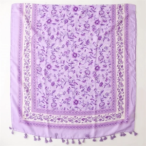 Detail of purple floral scarf featuring bohemian patterns and delicate fringe edges