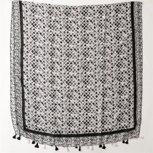 Close-up of black and white cross-patterned scarf with decorative tassel details