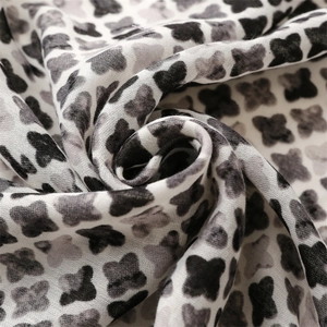 Detailed view of the soft cotton-linen texture and four-leaf clover pattern on the scarf