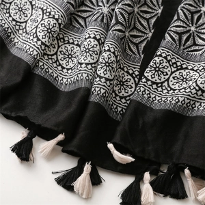 Detailed view of bohemian shawl featuring geometric patterns and black beige tassels