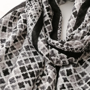 Detail of soft black and white patterned scarf showing clover texture and elegant fringe