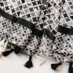 Close-up of cotton-linen feel scarf featuring star patterns and decorative fringe edges