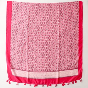 Detail of rose pink scarf featuring white geometric star patterns and elegant fringe trim