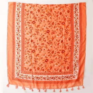Detailed view of the orange floral print cotton-linen scarf with delicate fringe edges