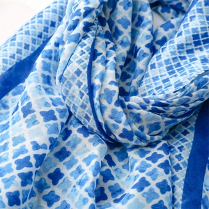 Detailed close-up of soft blue and white floral diamond pattern scarf fabric