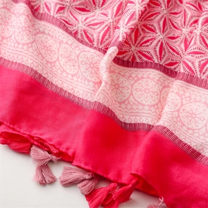 Close-up of pink linen-touch scarf featuring geometric floral patterns and soft tassels