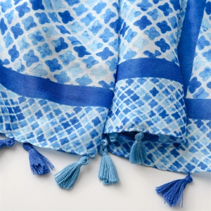 Close-up of blue cotton linen scarf with cross star patterns and soft tassel edges