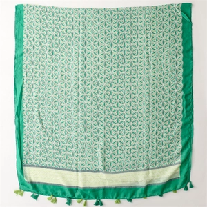 Detail of green and white floral geometric pattern scarf with soft hanging tassels