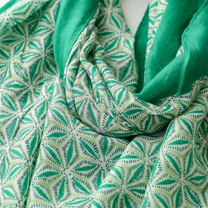 Close-up of a soft green scarf showing geometric leaf patterns and delicate woven textures