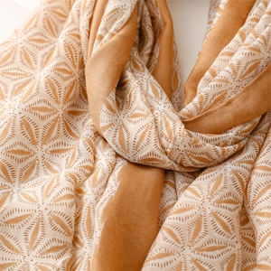 Detailed close-up of soft linen-touch scarf with geometric patterns and fringe detail