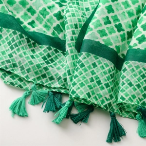 Detail of green geometric pattern scarf showing cotton-linen texture and tassels