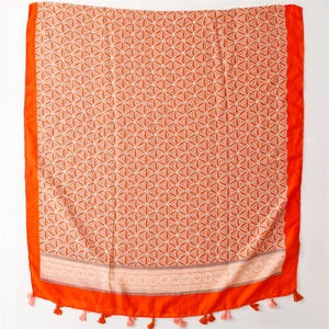 Detail of orange and white geometric scarf featuring elegant fringe tassels