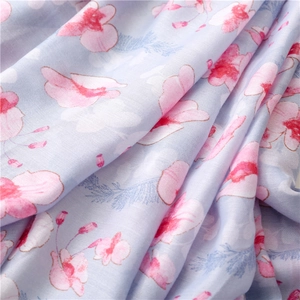 Detail of floral printed scarf showing soft linen texture and delicate tassel details