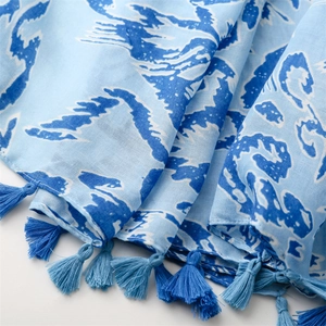 Detailaufnahme des weichen blau-weißen Baumwollschals mit Wellenmuster und Fransen