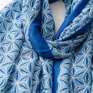 Detail of blue geometric leaf pattern and soft tassel texture on silk blend scarf