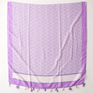 Detail view of purple printed scarf with white geometric stars and fringe tassels