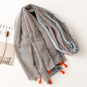Ethnic geometric scarf with orange tassels and blue rhombus pattern on white backdrop