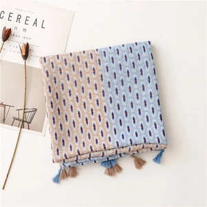 Detail of bohemian scarf with geometric patterns, blue tassels, and soft linen texture