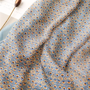 Detail of soft geometric pop art scarf with silky texture and vibrant orange-blue patterns