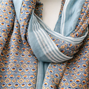 Detail view of ethnic geometric pattern scarf with blue and orange contrast print