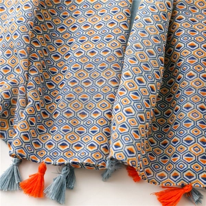 Close-up of geometric pattern scarf with detailed orange and gray tassel fringes