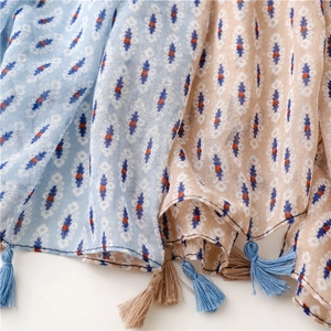 Detailed macro view of geometric ethnic patterns and blue tassel on cotton linen scarf