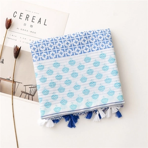 Detail of blue and white geometric print scarf with tassels on minimalist background