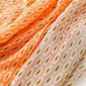 Detailed macro view of bohemian floral print fabric with orange and grey geometric patterns