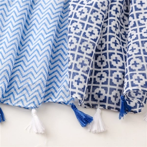 Detail of blue geometric chevron and square pattern scarf with cotton feel fringe tassels
